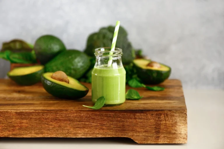 Avocado spinach green smoothies bottle standing kitchen table front view